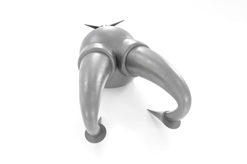 May include: A silver metal object with two curved horns and a pointed top. The object has a smooth, metallic finish and appears to be a decorative piece.