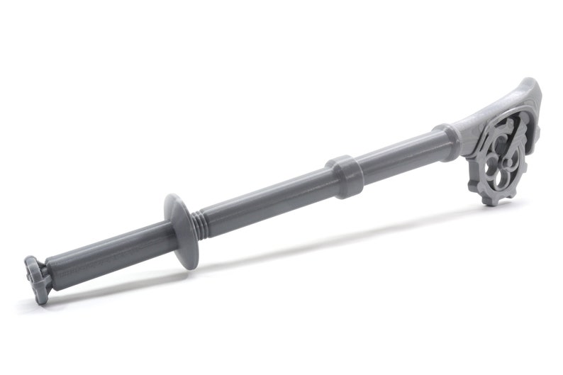 May include: A gray plastic tool with a gear-like handle and a threaded end. The tool is designed for installing drywall anchors.