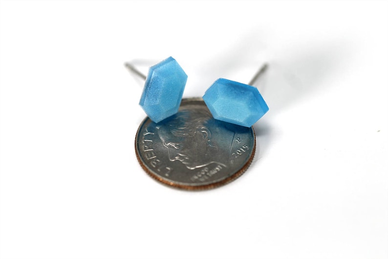 K&ouml;nnte beinhalten: Ein Paar blaue Edelsteinohrringe mit silbernen Stiften. Die Ohrringe werden neben einer 10-Cent-M&uuml;nze zur Gr&ouml;&szlig;enreferenz gezeigt.