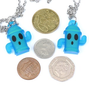 May include: Two blue plastic necklaces with a cartoon fire hydrant pendant. Each necklace has a silver chain and is displayed with coins.