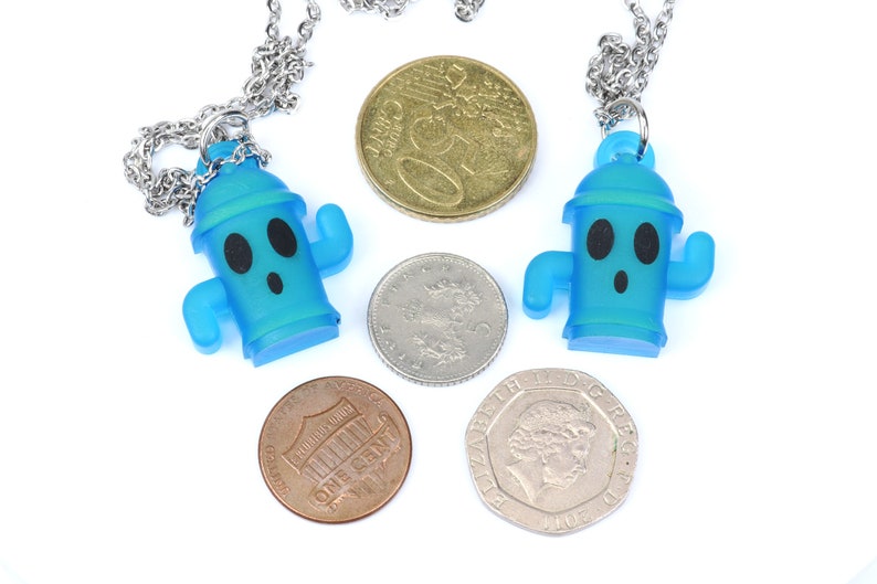 May include: Two blue plastic necklaces with a cartoon fire hydrant pendant. Each necklace has a silver chain and is displayed with coins.