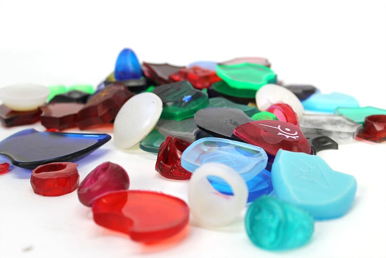 Puede incluir: Una colecci&oacute;n de formas de pl&aacute;stico transl&uacute;cido de colores, que incluyen c&iacute;rculos, cuadrados y tri&aacute;ngulos. Algunas de las formas tienen dise&ntilde;os o patrones.