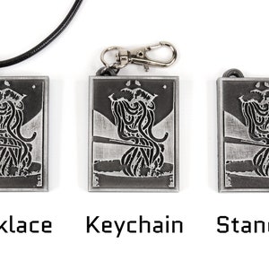 May include: Three silver metal pendants with a black and white image of a person eating noodles. The pendants are shown in three different styles: necklace, keychain, and standard.