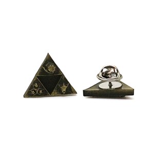 May include: A gold-toned triangular pin with a black and white design. The pin features a stylized image of a triangle with a symbol inside. The back of the pin has a safety clasp.