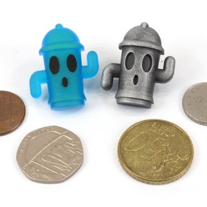 May include: Two small fire hydrant figurines, one blue and one silver, with a surprised expression on their faces. The figurines are sitting on a white surface with four coins.