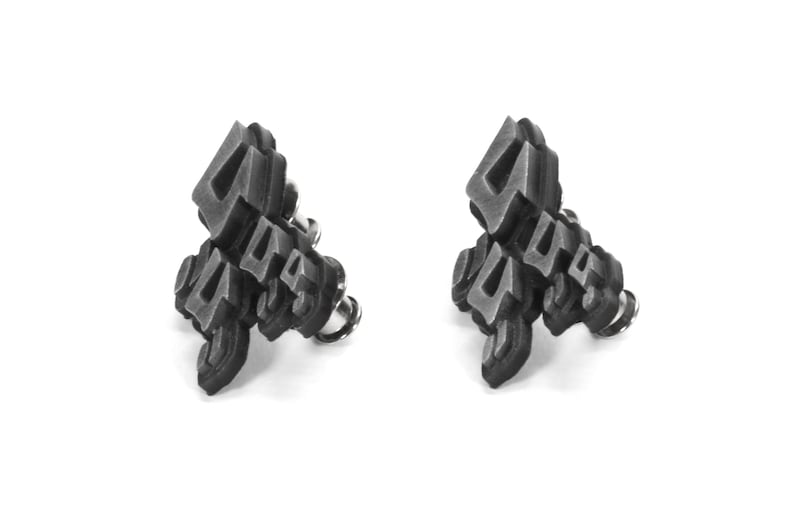 May include: A pair of silver-toned earrings with a geometric design featuring the number four. The earrings are made of metal and have a post back.