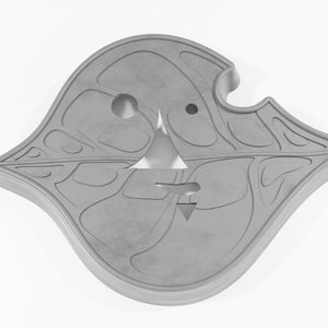 May include: A gray, leaf-shaped, decorative wall hanging with a carved design and two holes.