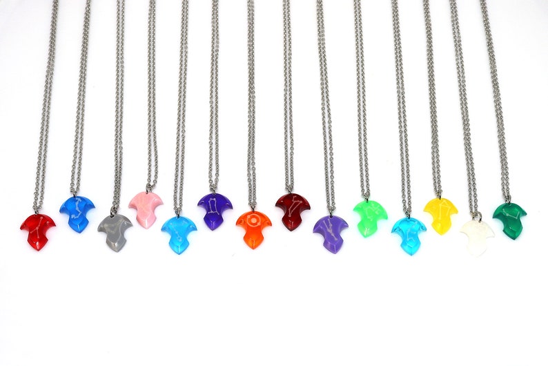 Puede incluir: Un conjunto de 12 collares con colgantes de diferentes colores. Cada colgante tiene forma de p&aacute;jaro y tiene un color diferente, incluyendo rojo, azul, gris, rosa, morado, naranja, verde, turquesa, amarillo, blanco y verde.