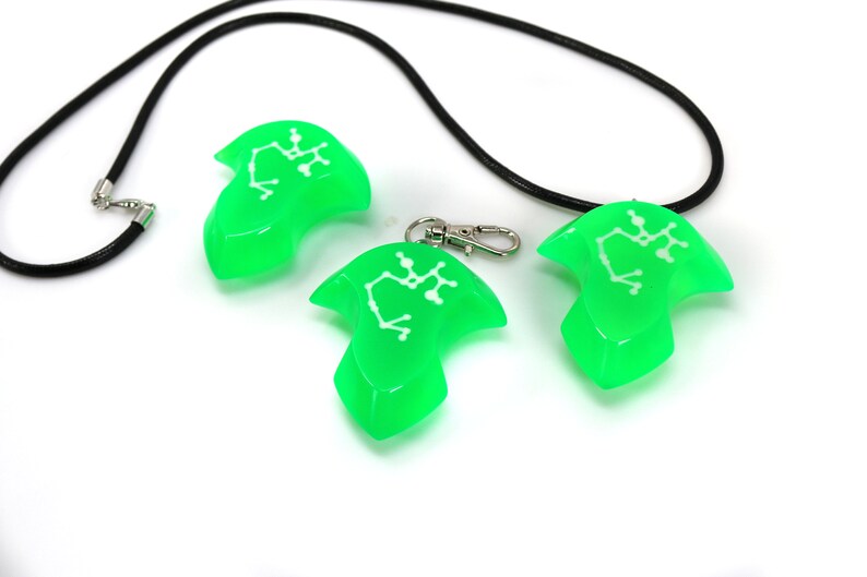 May include: Three green pendant necklaces with a black cord. Each pendant features a white constellation design.