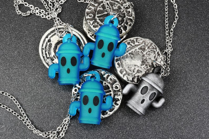 May include: Three silver necklaces with blue and silver fire hydrant charms. The fire hydrant charms have a surprised expression with two eyes and a mouth.