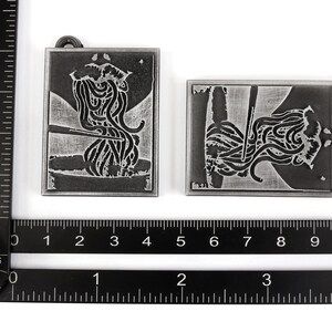 May include: Two silver metal keychains with a design of noodles and chopsticks. The keychains are attached to a silver metal ring.