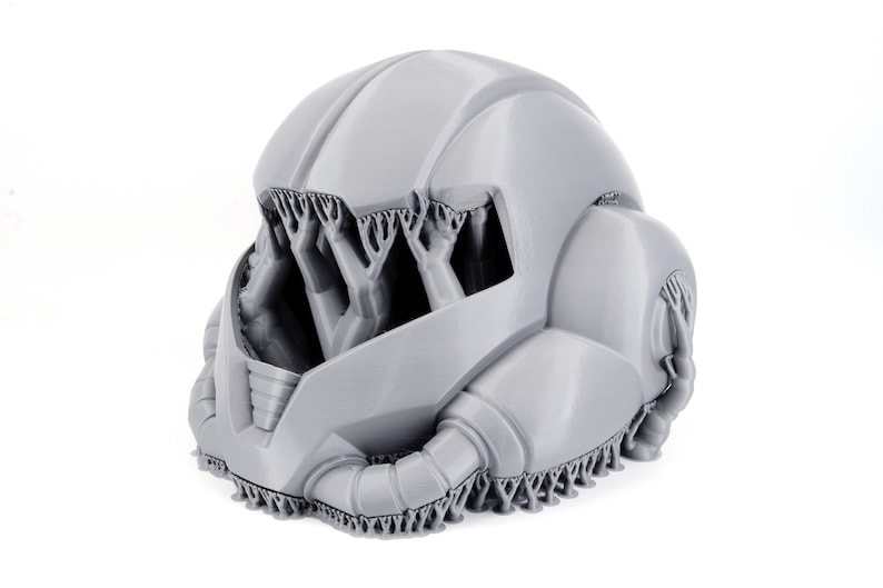 May include: A 3D printed gray helmet with a detailed design. The helmet has a textured surface and intricate details.