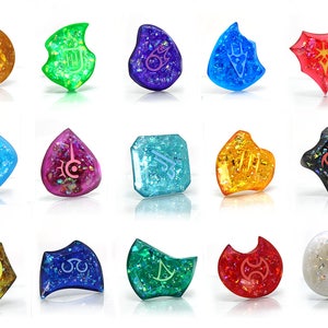 May include: A set of 15 colorful resin charms with different shapes and symbols. Each charm has a unique design and is filled with glitter. The charms are perfect for jewelry making, scrapbooking, and other craft projects.