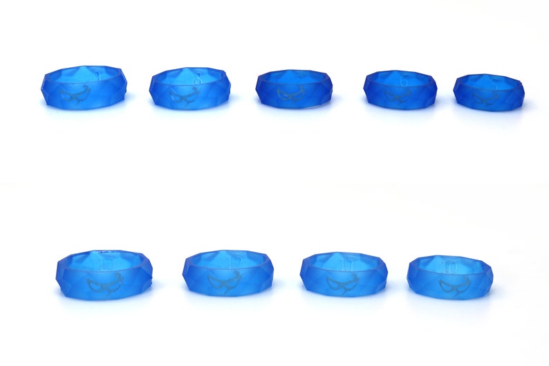 May include: Eight blue silicone rings with a geometric design and a white graphic of a stylized eye. The rings are arranged in two rows of four.