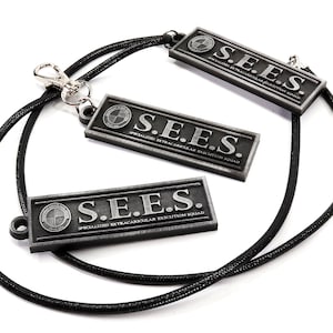 May include: A black lanyard with three silver metal tags that read "S.E.E.S. SPECIALIZED EXTRACURRICULAR EXECUTION SQUAD".