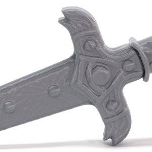 May include: A gray plastic sword with a detailed handle and a sharp point. The sword has a textured surface and a decorative design on the handle.