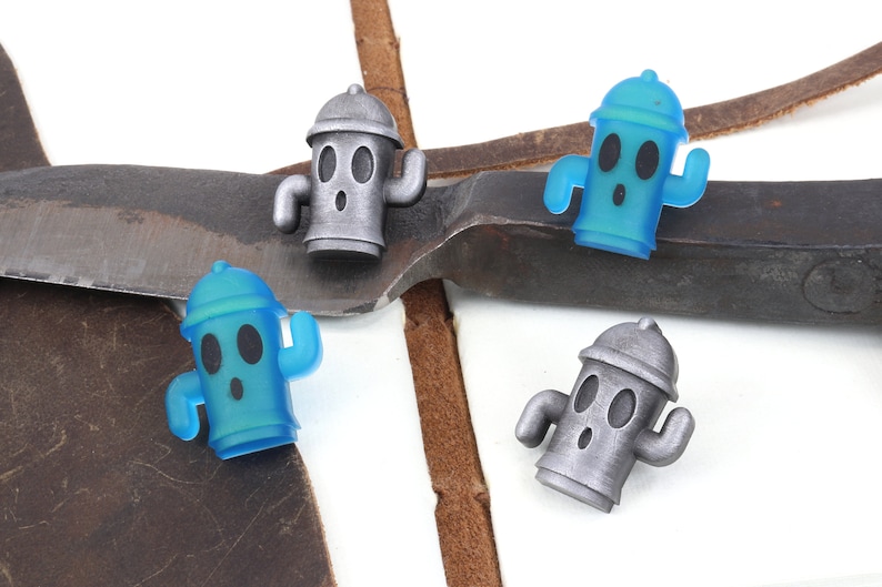 May include: Three small, cartoon-style fire hydrant figurines. One is silver, and two are blue.
