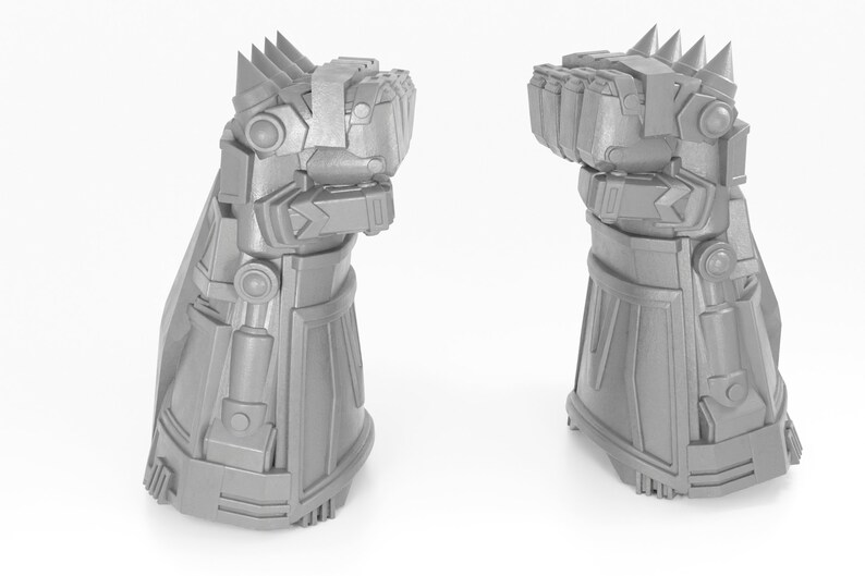 May include: A 3D printed model of a silver robotic hand with a spiked gauntlet. The hand is clenched into a fist and the gauntlet has a detailed design.