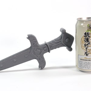 May include: A gray 3D printed sword with intricate details, next to a can of Japanese beer labeled "Koshuhikari Ari Echigo" with Japanese text.