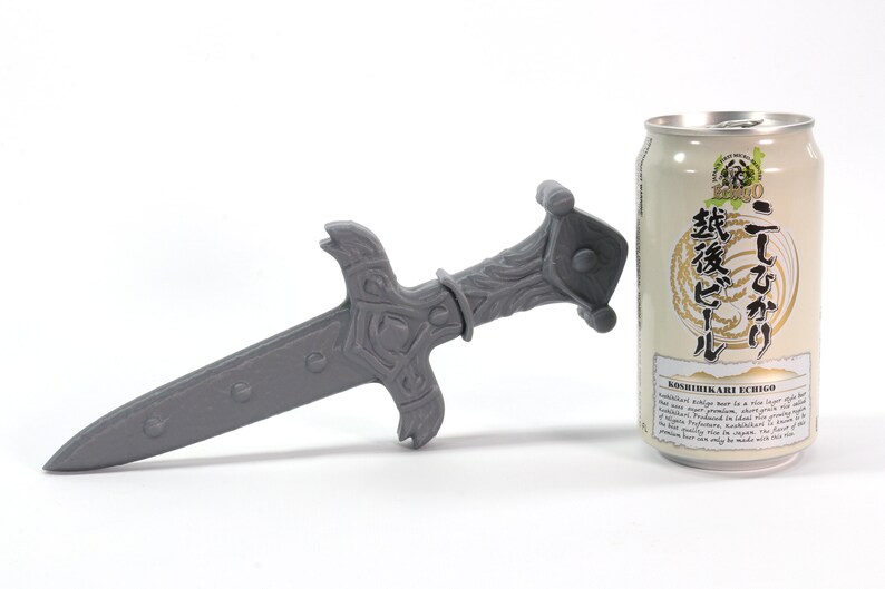 May include: A gray 3D printed sword with intricate details, next to a can of Japanese beer labeled "Koshuhikari Ari Echigo" with Japanese text.