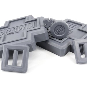 May include: Gray plastic building blocks with the word "GROWTH" printed on one block and a round gray block with the word "HD" printed on it.