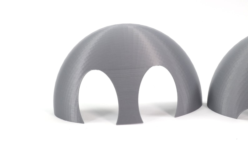 May include: Two gray 3D printed half dome shapes with two holes cut out of the bottom of each dome.