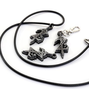 May include: A black cord necklace with three silver charms. The charms are stylized designs of the letter "Z".