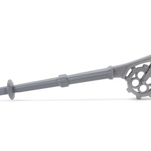 May include: A gray plastic tool with a long handle and a gear-like mechanism at the end. The tool is designed for attaching drywall.