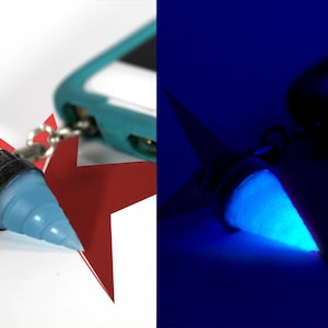 May include: A blue glow-in-the-dark keychain shaped like a spiral. The keychain is attached to a red star-shaped charm.