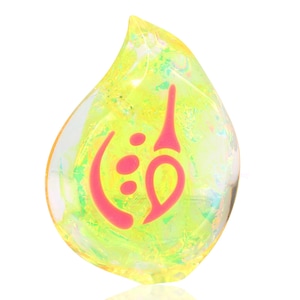 May include: A teardrop-shaped glass pendant with a pink swirl design inside. The glass is iridescent and has a yellow hue.