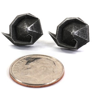 May include: A pair of silver geometric earrings, each shaped like a spiral, shown next to a US dime for scale.