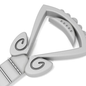 May include: A silver guitar capo with a unique design featuring two curved, spiral-shaped accents on either side of the capo. The capo has a series of small, round knobs on the top.