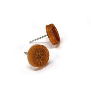May include: A pair of gold-toned stud earrings with a textured finish.