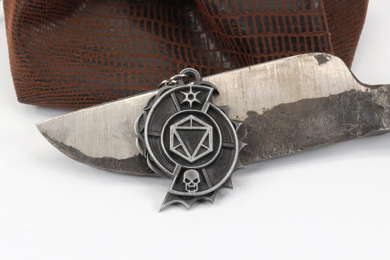 May include: A silver metal keychain with a skull, a 20-sided die, and a star design.