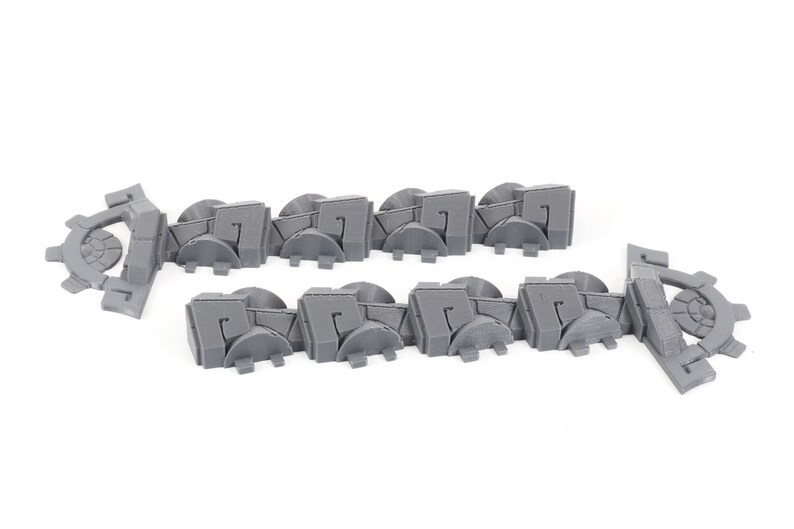 May include: A set of 12 gray plastic wall pieces with a geometric design. The pieces are designed to be used as a border or trim for a model or diorama.