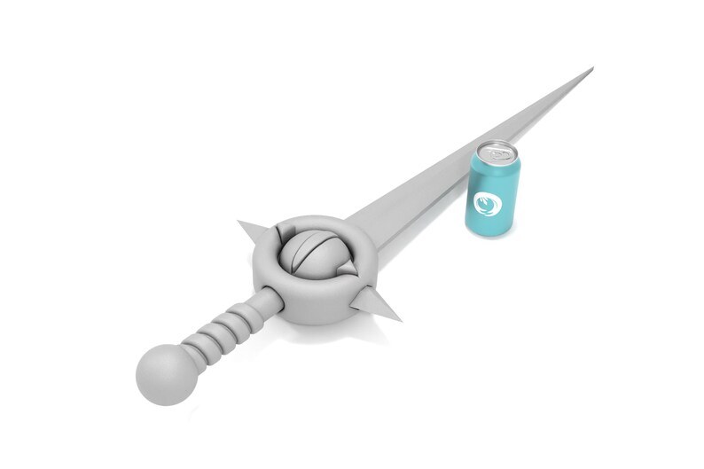 May include: A silver sword with a round, textured handle and a blue can with a white logo. The sword is lying on a white surface.