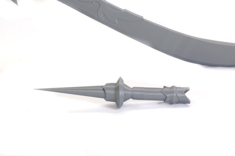 May include: A gray plastic sword and a gray plastic dagger. The sword has a curved blade with a decorative design. The dagger has a sharp point and a handle with a decorative design.