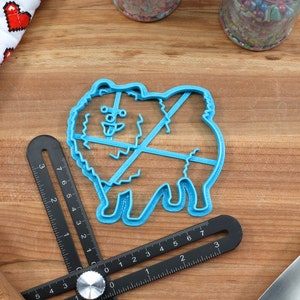 May include: Blue plastic cookie cutter shaped like a Pomeranian dog. The cutter has a detailed design with a fluffy tail and paws.