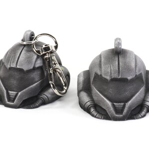 Puede incluir: Un llavero de metal de color plateado que presenta una r&eacute;plica detallada de un casco espacial. El llavero tiene un anillo de metal plateado y un cierre de metal plateado.
