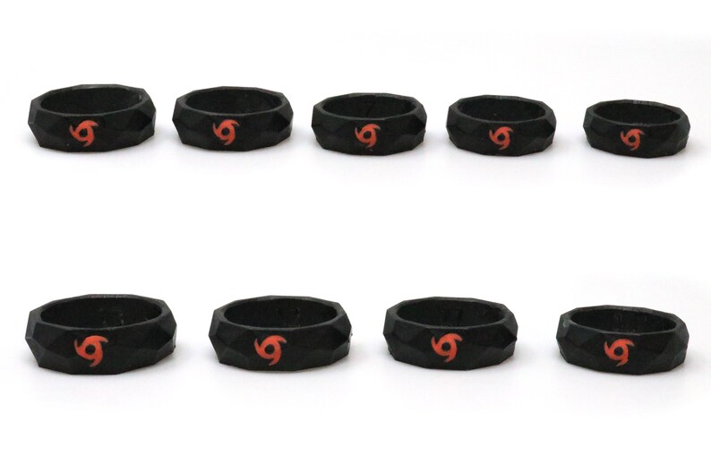 May include: Eight black silicone rings with a red and orange swirl design. The rings are all different sizes.