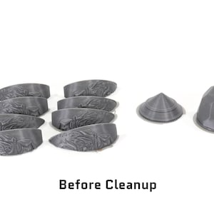 May include: A collection of eight grey 3D printed plastic pieces, including seven curved pieces and two dome-shaped pieces. The pieces are arranged on a white surface. Before Cleanup.