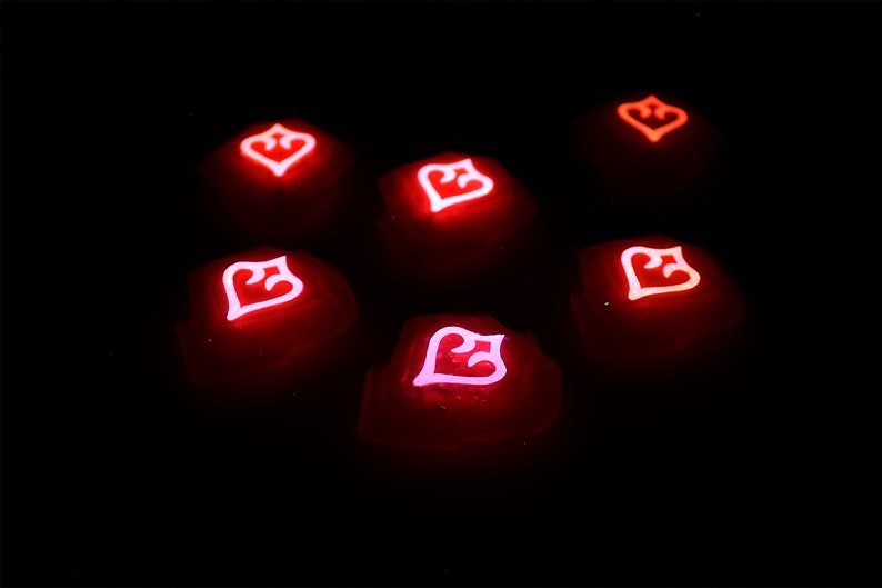 May include: Seven red glowing dice with a white heart symbol on each face. The dice are arranged in a circle on a black background.