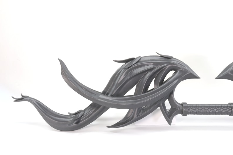 May include: A gray 3D printed fantasy weapon with a long, curved blade and a textured handle. The blade is shaped like a series of flowing, organic shapes.