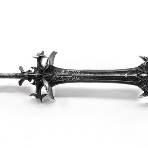 May include: A silver-colored sword with a detailed, ornate design. The sword has a sharp point and a double-edged blade.