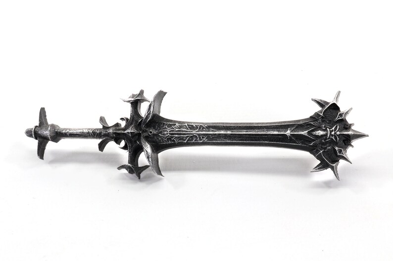 May include: A silver-colored sword with a detailed, ornate design. The sword has a sharp point and a double-edged blade.