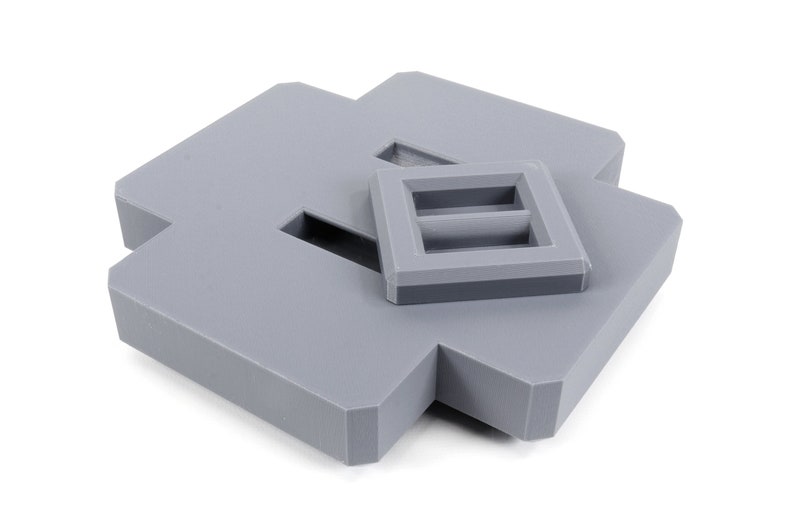 May include: A gray plastic box with a smaller gray plastic box inside. The smaller box has two rectangular openings.
