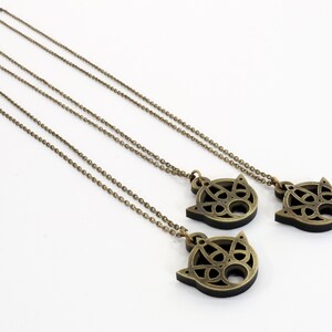 May include: Three gold necklaces with intricate, circular, Celtic-style pendants. The pendants are in the shape of a cat's face.