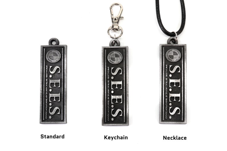 May include: Three silver metal pendants with the text "S.E.E.S. SPECIALIZED EXTRACARKULAR EXECUTION SQUAD" and a logo. The pendants are shown in three variations: standard, keychain, and necklace.