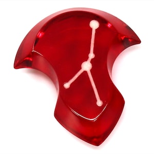 Op de afbeelding: Een rode hars hanger met het sterrenbeeld Kreeft. De sterren zijn wit gemarkeerd.