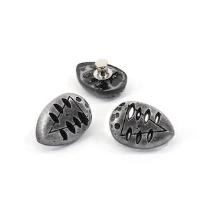 May include: Three silver-colored metal buttons with a black design. Each button features a stylized tree design with a triangular shape and leaf-like details.
